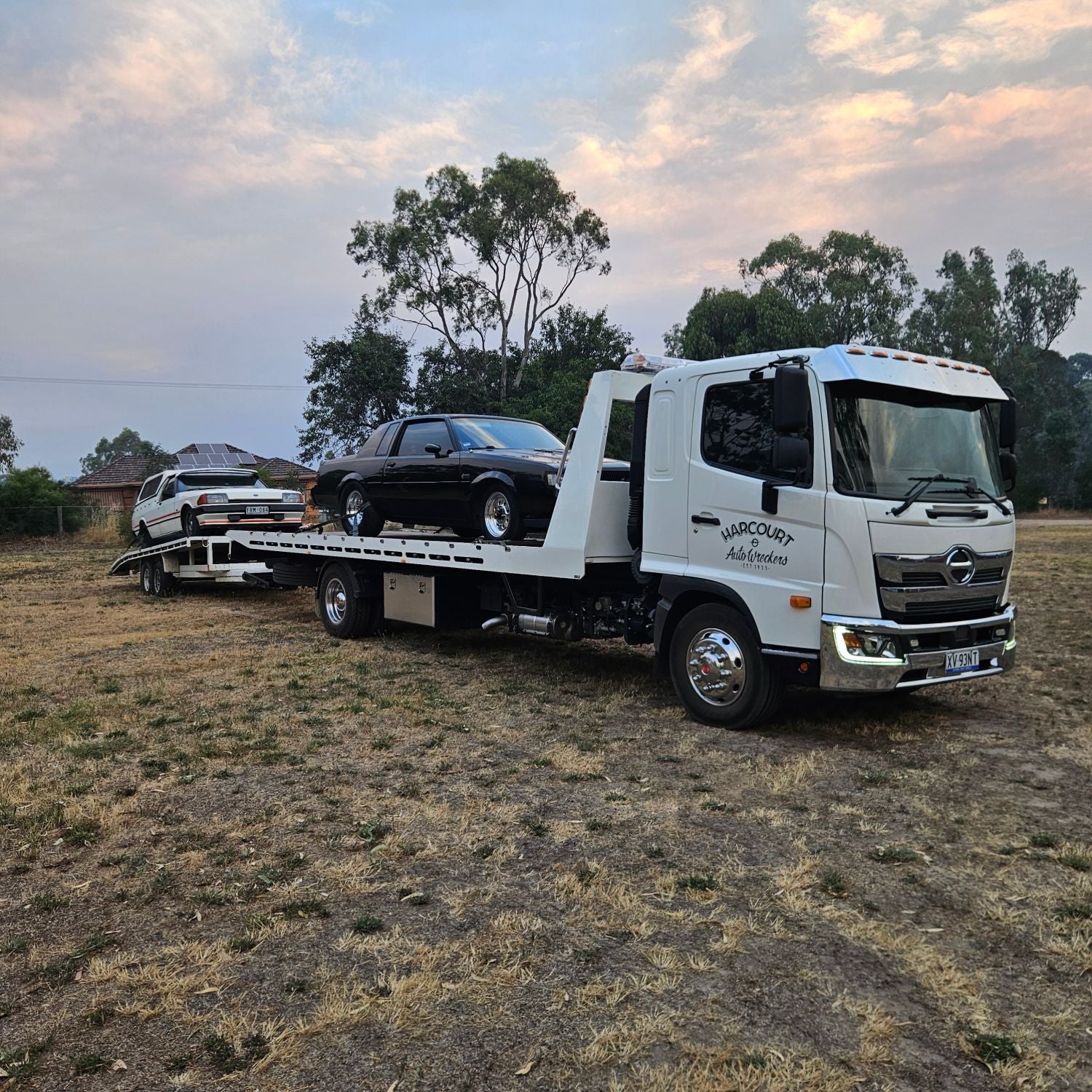Harcourt Auto Wreckers tilt tray loading a car at dusk