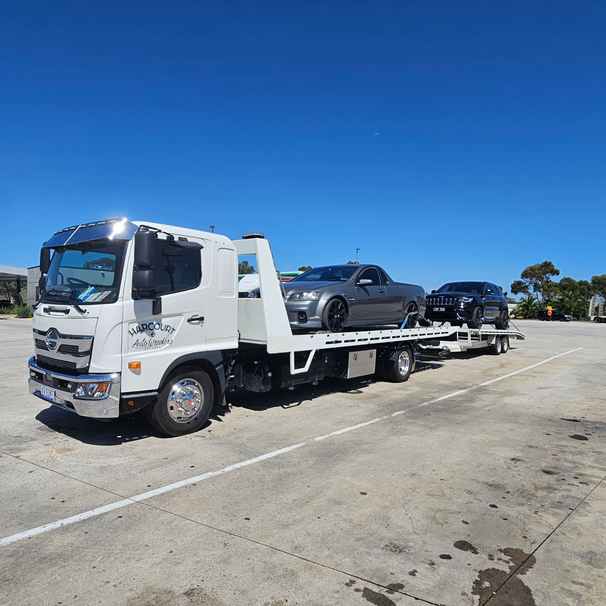 Harcourt Auto Wreckers truck and trailer loaded with two cars